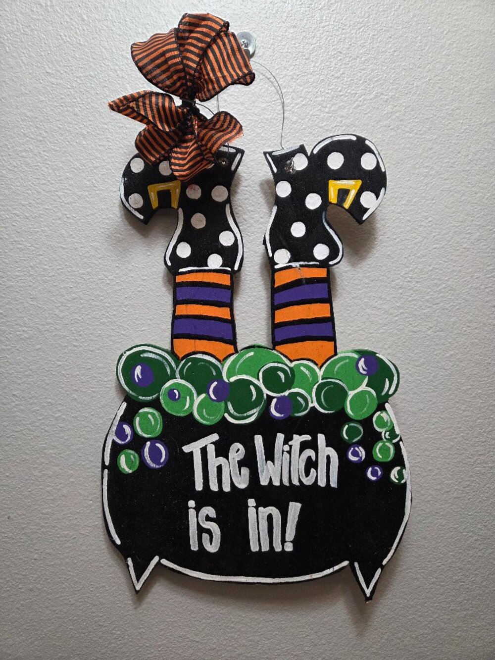 Handmade wooden Halloween door hanger shaped like a bubbling cauldron